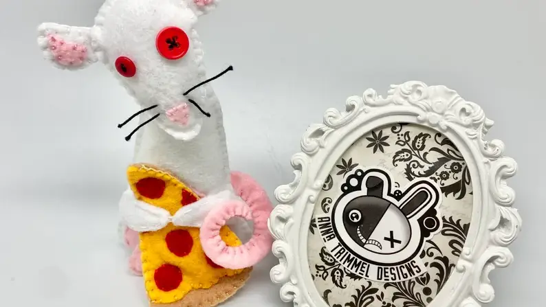 Plush white rat holding pepperoni pizza