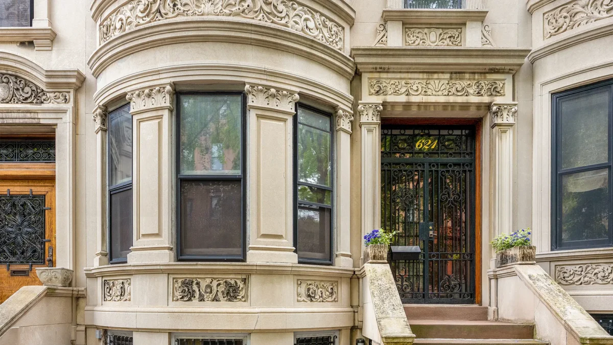 Limestone townhouse exterior with bay window and stoop steps
