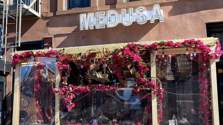 Sign reading "Medusa" above flowery patio