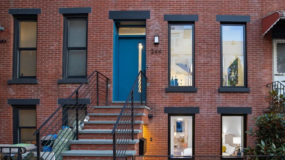 Modern brick building exterior with blue front door