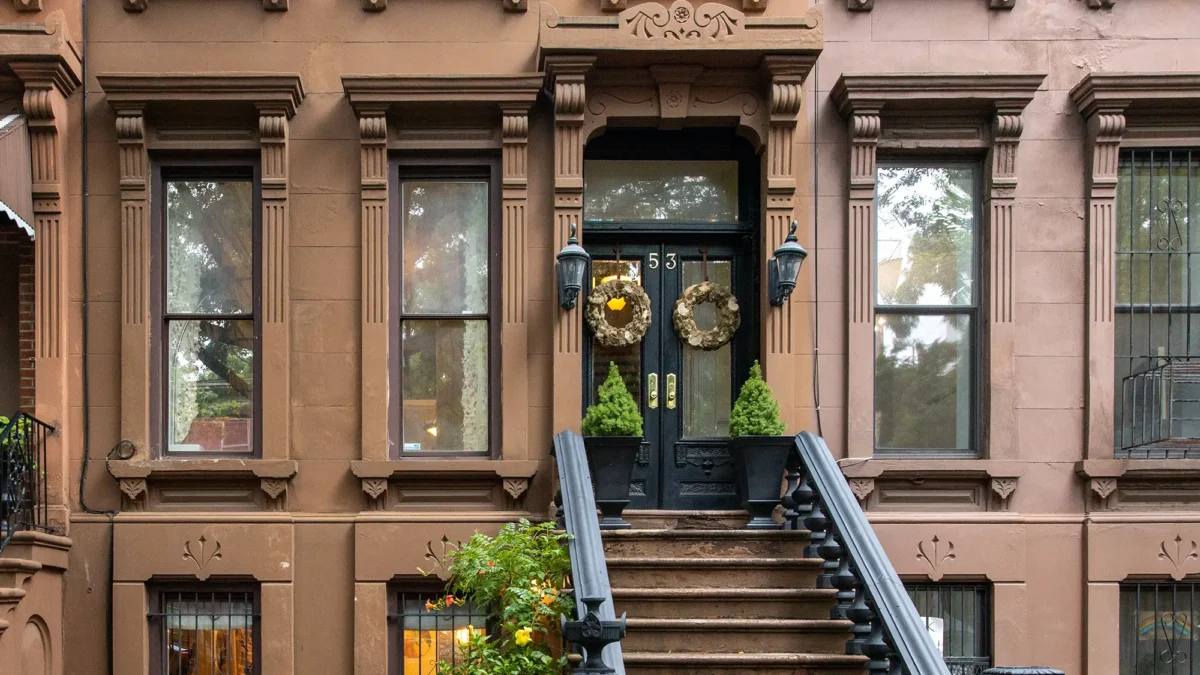 Brownstone exterior and stoop with wreaths on double door entry