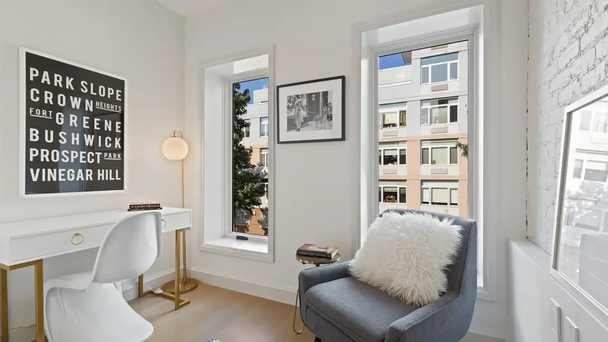 Sitting room with two picture windows and wall art with Brooklyn neighborhood names written on it