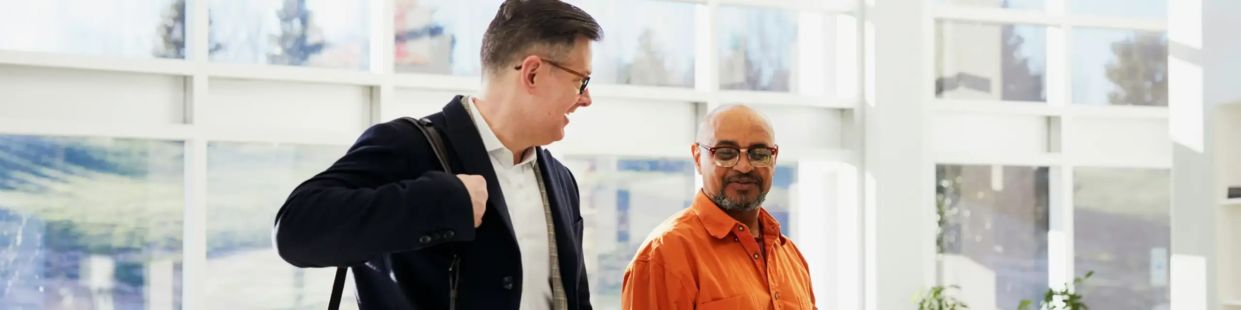 Two men smiling and talking