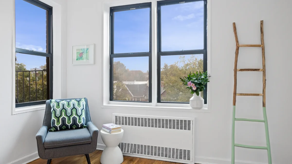Staged home with corner chair flanking windows and decorative ladder
